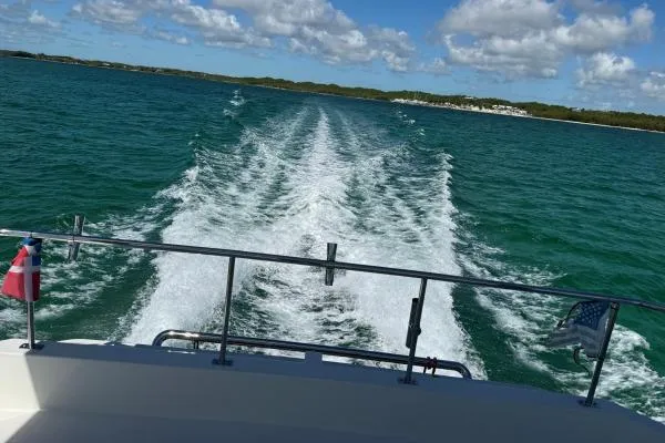 Andiamo Yacht Photos Pics Wake trail behind 2020 Leopard 43 Powercat on clear blue water under a sunny sky.