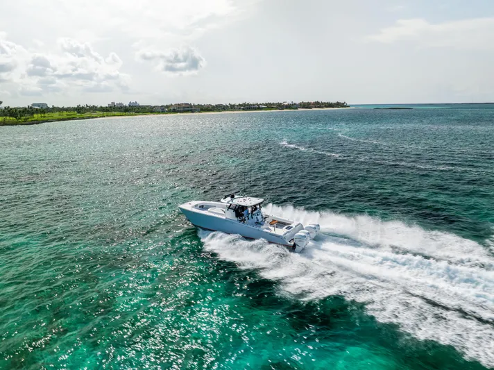  Yacht Photos Pics A 2022 Freeman 37 VH boat cruising on clear turquoise waters near a lush coastline.