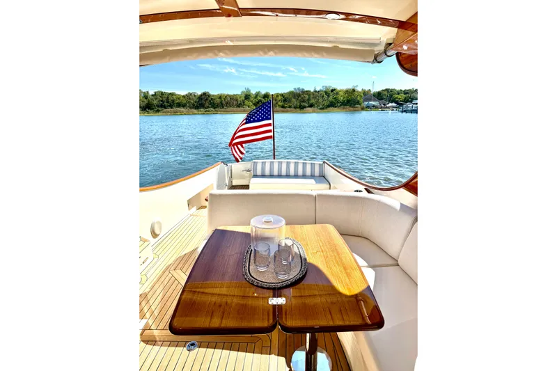 Sterling Yacht Photos Pics 2024 Hinckley Picnic Boat 40 S interior with elegant seating and American flag on water.