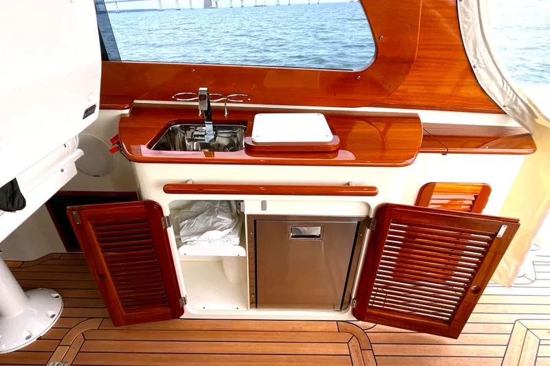 Sterling Yacht Photos Pics 2024 Hinckley Picnic Boat 40 S interior with wooden cabinetry and sink, overlooking the ocean.