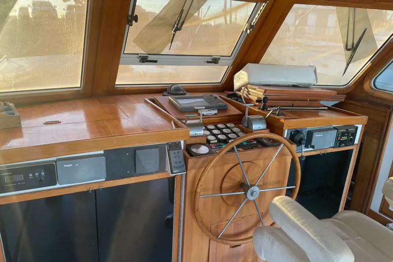  Yacht Photos Pics 1969 Islander 72 Aft Cabin Motor Yacht helm with wooden steering wheel and navigation equipment.