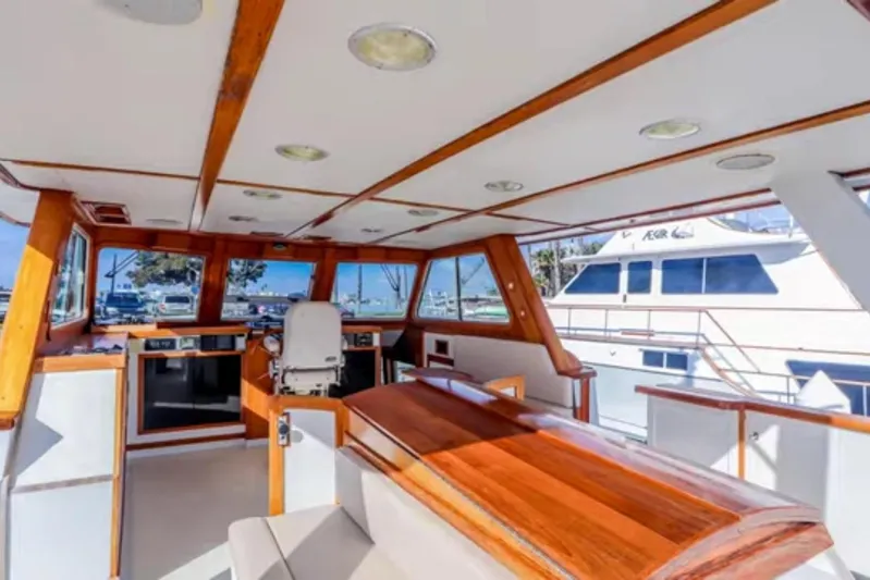  Yacht Photos Pics 1969 Islander 72 Aft Cabin Motor Yacht interior with wood accents and panoramic windows.