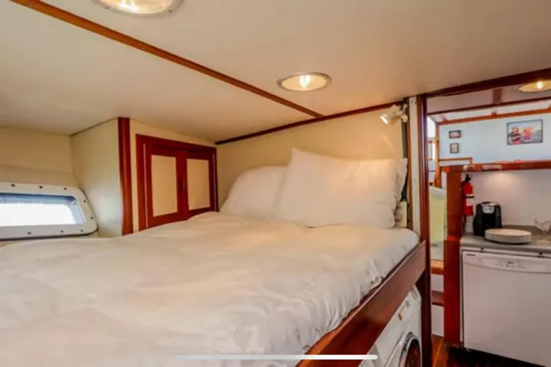  Yacht Photos Pics Cozy cabin interior of 1969 Islander 72 Aft Cabin Motor Yacht with bed and kitchenette.