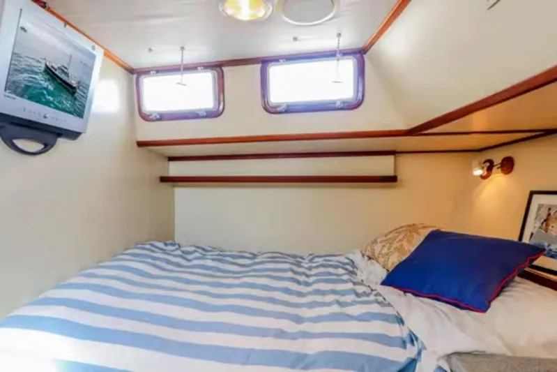  Yacht Photos Pics Cozy cabin interior of 1969 Islander 72 Aft Cabin Motor Yacht with striped bedding.