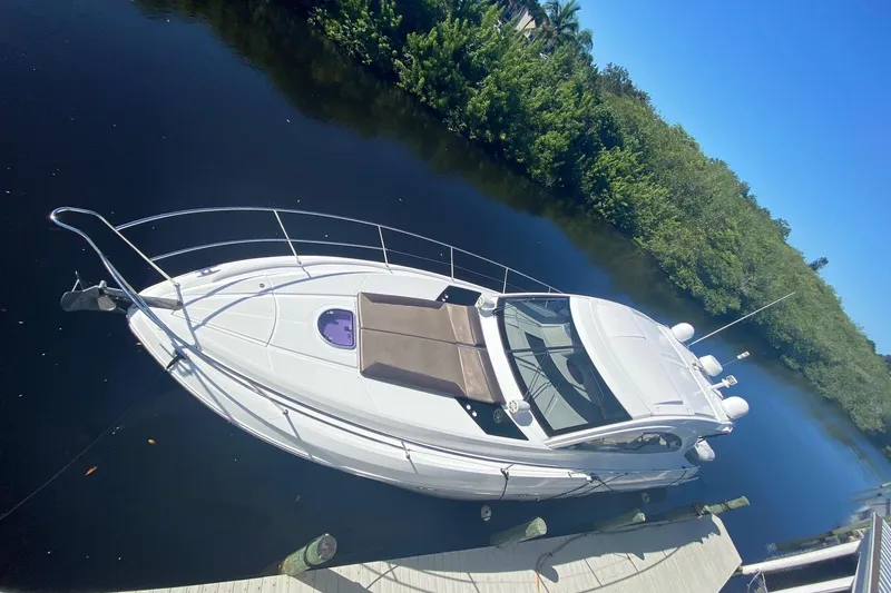 “amor Fati” Yacht Photos Pics 2014 Beneteau Gran Turismo 44 yacht docked on calm water, surrounded by lush greenery.