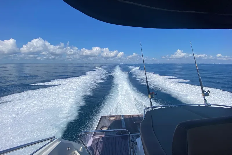 “amor Fati” Yacht Photos Pics Beneteau Gran Turismo 44 yacht cruising, leaving a wake in the ocean, under a clear blue sky.