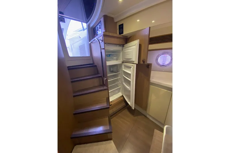 “amor Fati” Yacht Photos Pics Interior of 2014 Beneteau Gran Turismo 44 yacht with open refrigerator and wooden stairs.