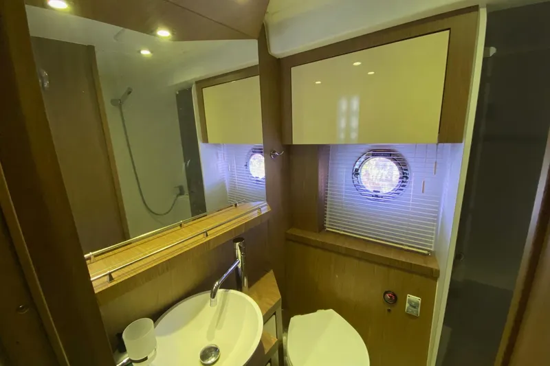 “amor Fati” Yacht Photos Pics Bathroom interior of 2014 Beneteau Gran Turismo 44 yacht, featuring sink, mirror, and porthole window.