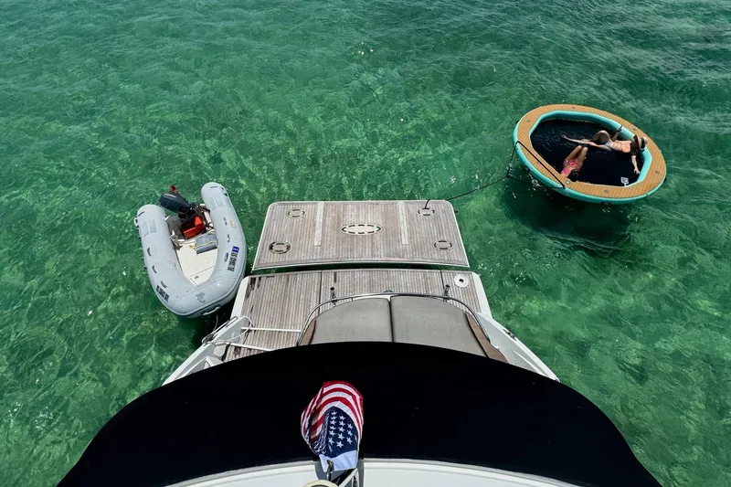 “amor Fati” Yacht Photos Pics Beneteau Gran Turismo 44 yacht with inflatable boat and floating lounge in clear water.