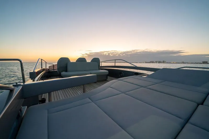  Yacht Photos Pics Luxurious 2022 Pershing 8X yacht deck at sunset, overlooking calm ocean waters.