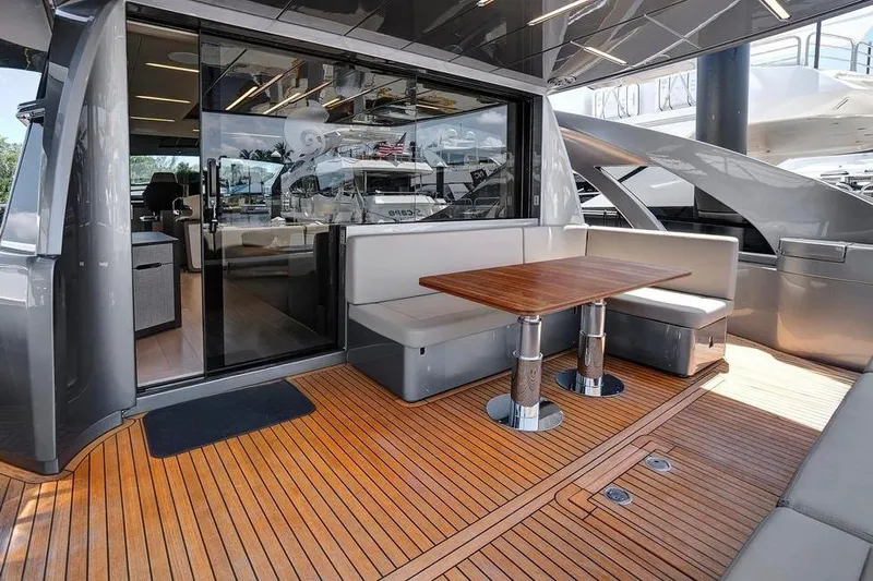  Yacht Photos Pics Luxurious 2022 Pershing 8X yacht deck with sleek seating and wooden table.