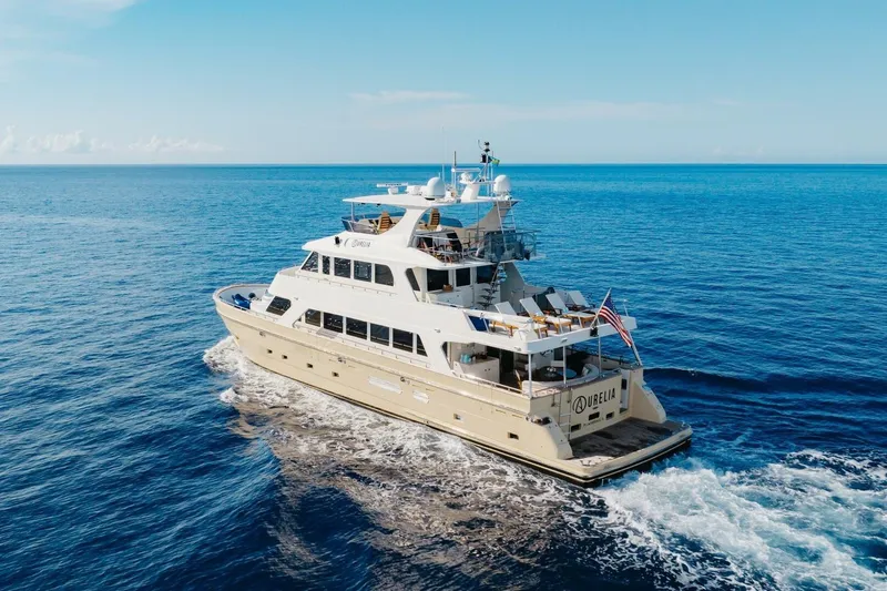 Aurelia Yacht Photos Pics Luxurious 2007 President Tri-Deck yacht cruising on open sea under clear blue sky.