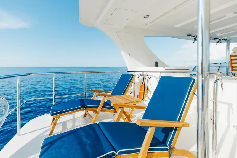 Aurelia Yacht Photos Pics Luxurious 2007 President Tri-Deck yacht deck with blue lounge chairs and ocean view.