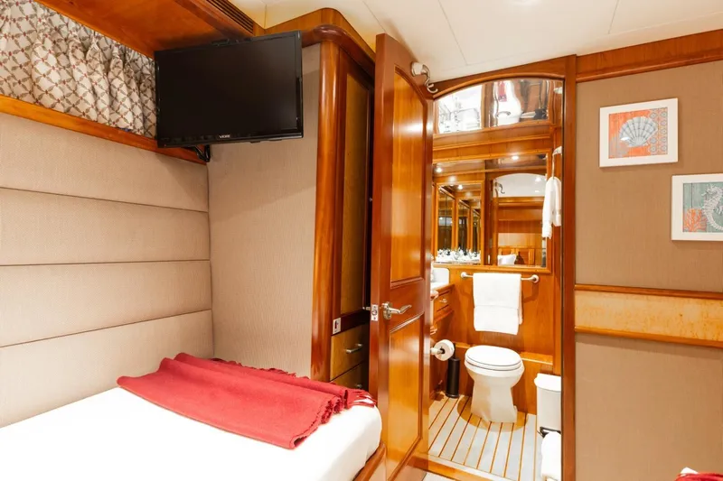 Aurelia Yacht Photos Pics Luxurious 2007 President Tri-Deck yacht cabin with ensuite bathroom, TV, and elegant wood finishes.