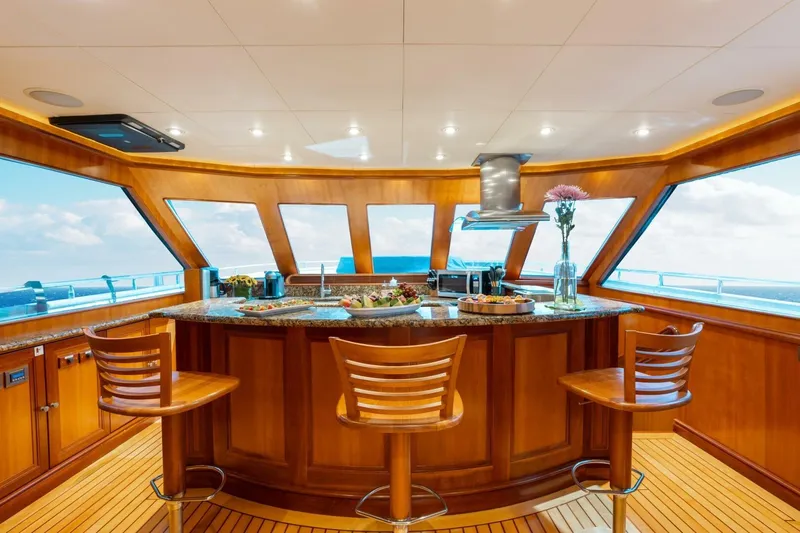 Aurelia Yacht Photos Pics Luxurious 2007 President Tri-Deck yacht interior with elegant wooden bar and panoramic ocean views.