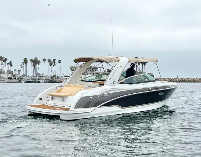  Yacht Photos Pics 2009 Formula 310 BR boat cruising on water near palm-lined shore.