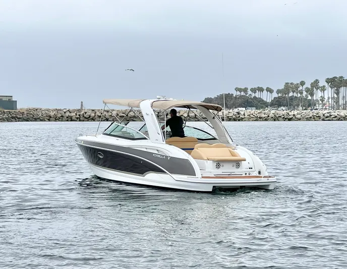  Yacht Photos Pics 2009 Formula 310 BR boat cruising on calm water near a rocky shoreline.