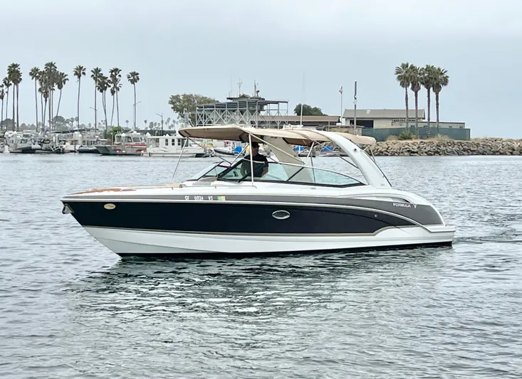  Yacht Photos Pics 2009 Formula 310 BR boat cruising in a marina with palm trees in the background.