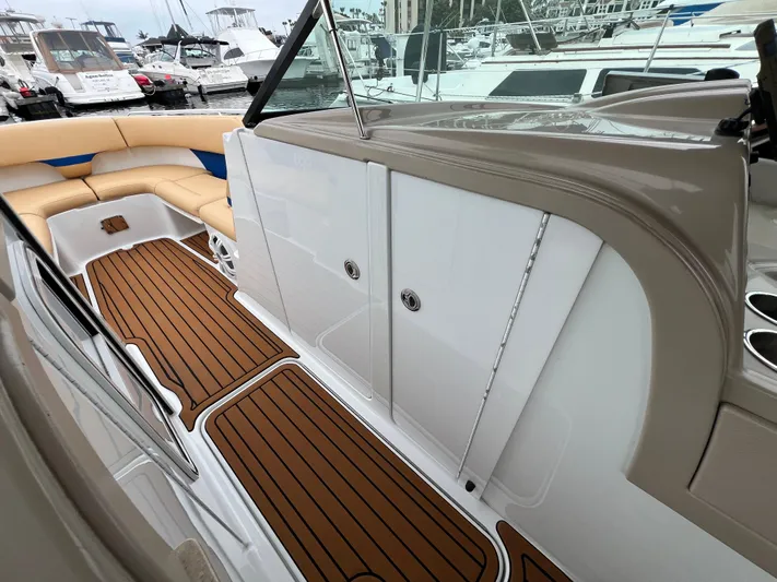  Yacht Photos Pics 2009 Formula 310 BR boat interior with teak flooring and beige seating at a marina.