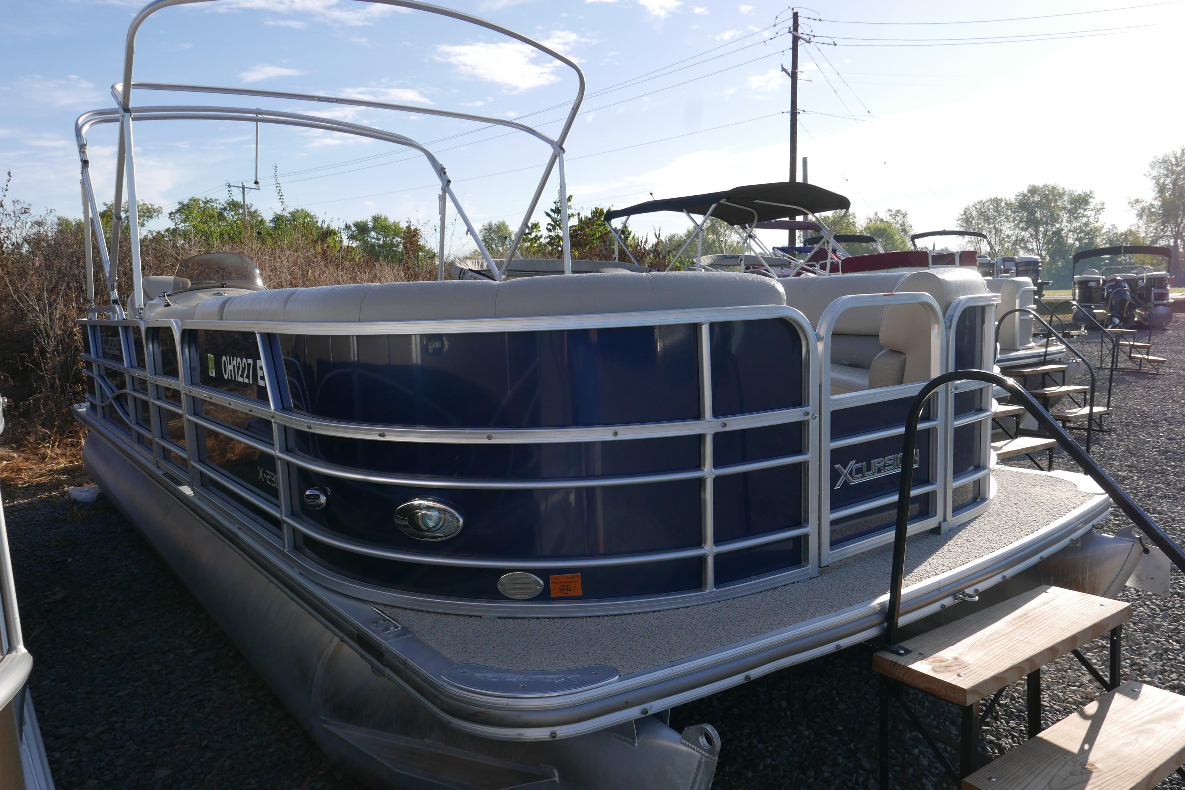 2012 Xcusrion x2312 pontoon boat with blue exterior, parked outdoors.