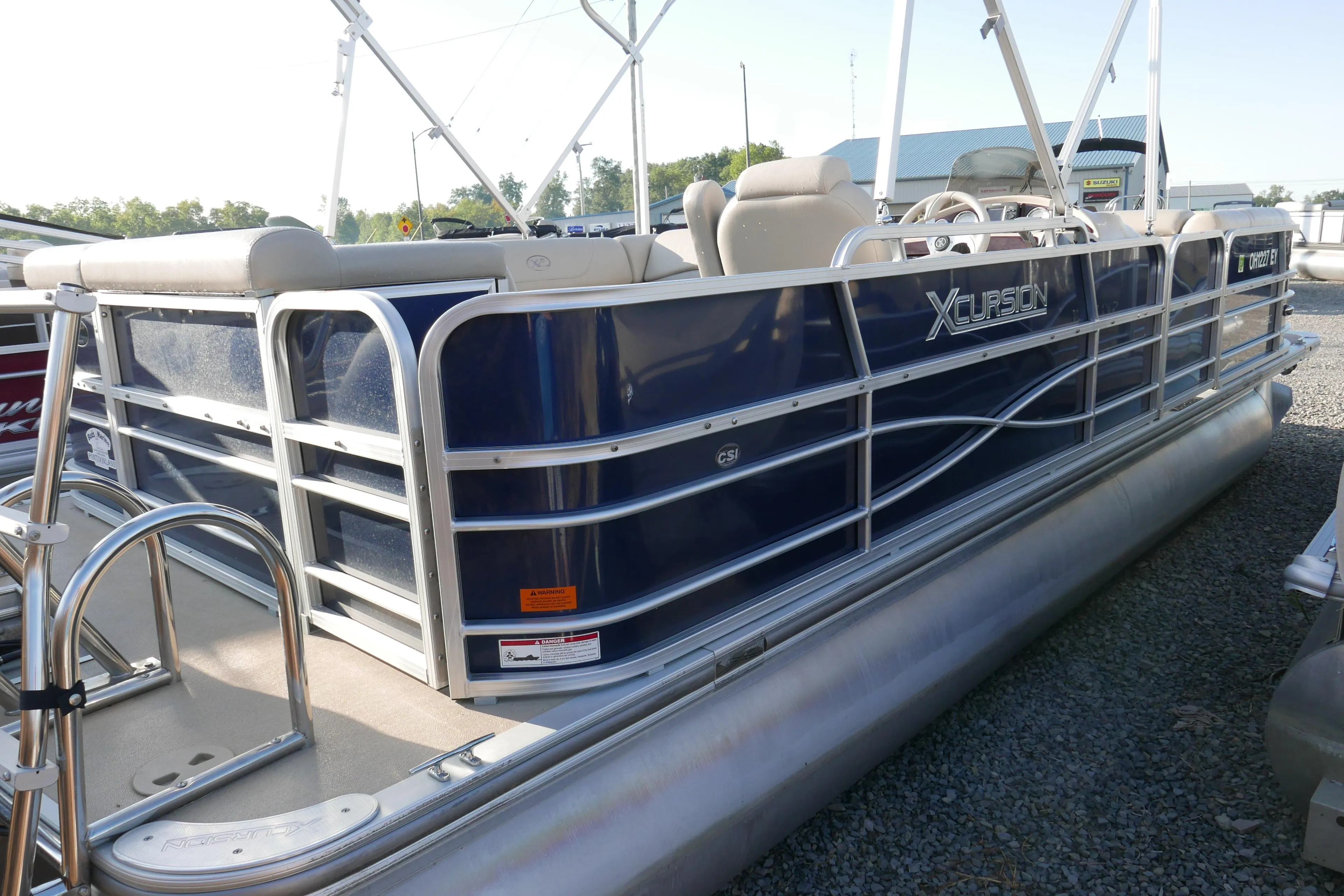 2012 Xcursion x2312 pontoon boat with blue exterior and silver railings.