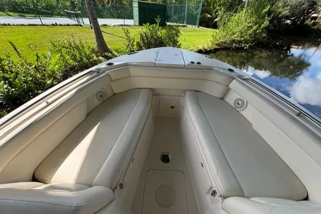  Yacht Photos Pics 2019 Grady-White Freedom 285 boat interior with cushioned seating, near lush greenery and water.