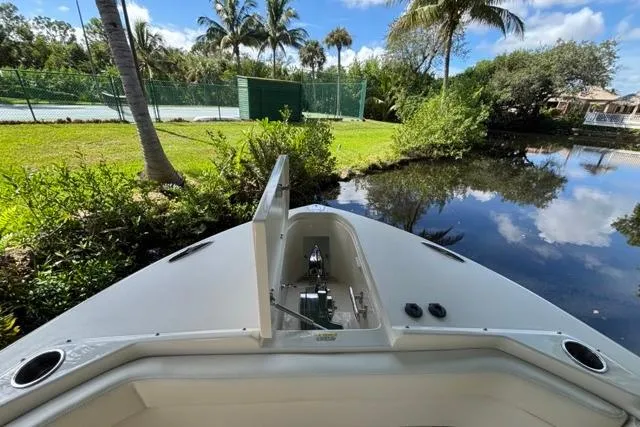  Yacht Photos Pics 2019 Grady-White Freedom 285 boat docked near lush greenery and calm water.