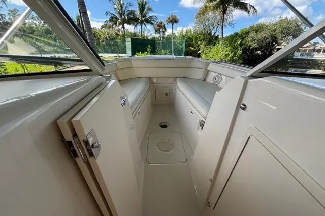  Yacht Photos Pics 2019 Grady-White Freedom 285 boat interior with seating and storage, surrounded by lush greenery.