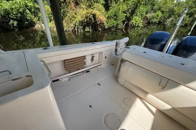  Yacht Photos Pics 2019 Grady-White Freedom 285 boat interior with seating, near lush greenery.