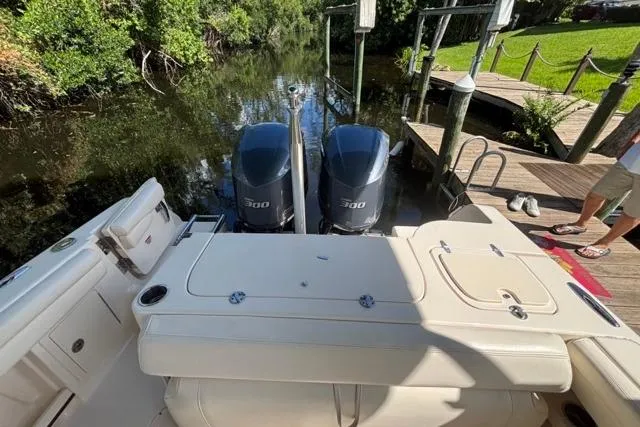  Yacht Photos Pics 2019 Grady-White Freedom 285 boat with twin 300 horsepower engines docked by a lush riverside.