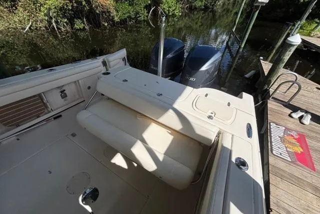  Yacht Photos Pics 2019 Grady-White Freedom 285 boat interior with dual engines, docked by a wooden pier.