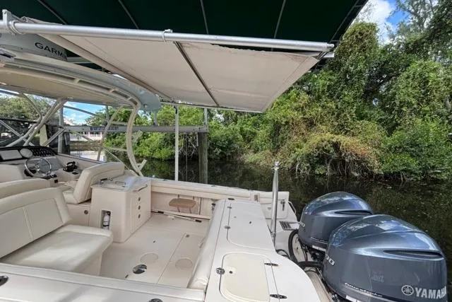  Yacht Photos Pics 2019 Grady-White Freedom 285 boat with Yamaha engines, docked near lush greenery.