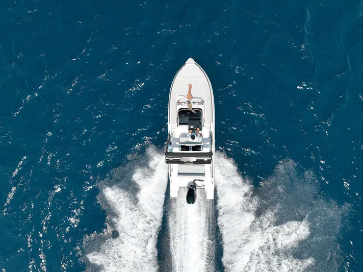  Yacht Photos Pics Aerial view of 2025 Ranieri NEXT 255 LX boat cruising on blue ocean waters.