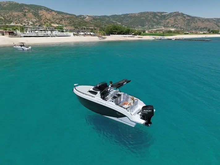  Yacht Photos Pics 2025 Ranieri NEXT 255 LX boat on clear turquoise water near a sandy beach.