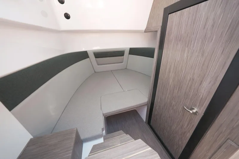  Yacht Photos Pics Interior cabin of 2025 Ranieri NEXT 255 LX boat, featuring modern wood finish and seating area.