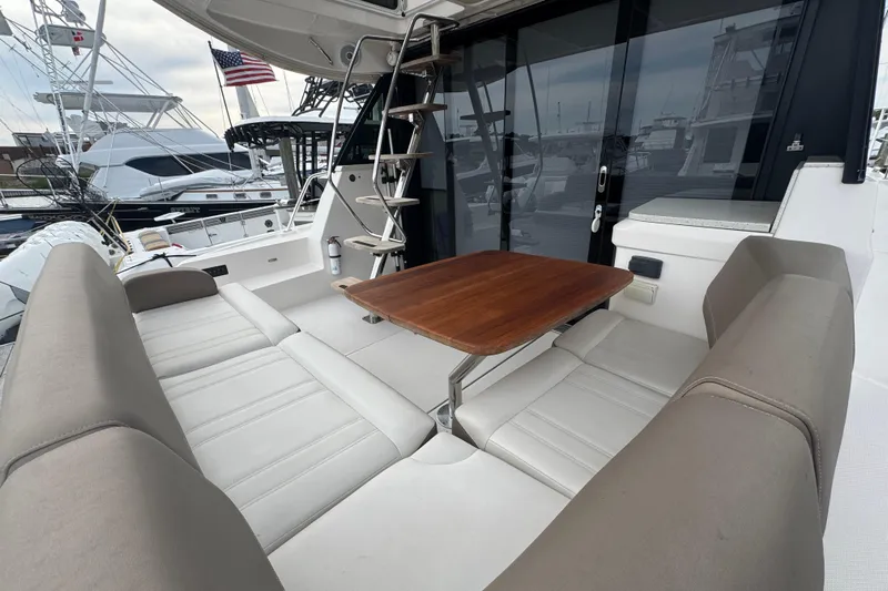 Blue Skies Yacht Photos Pics 2017 Regal 42 Fly yacht with outdoor seating and wooden table, docked at marina.