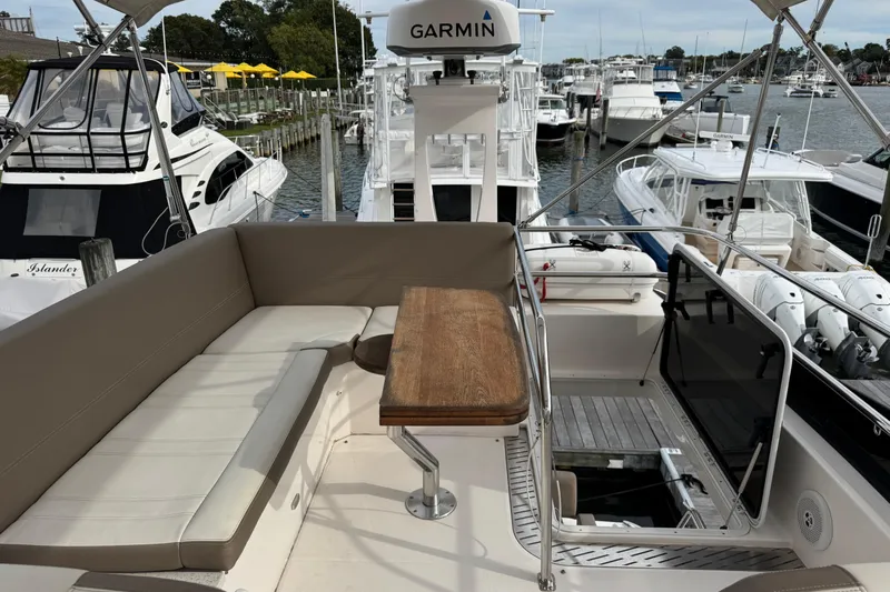 Blue Skies Yacht Photos Pics 2017 Regal 42 Fly yacht with seating area and wooden table, docked at marina.