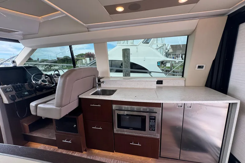 Blue Skies Yacht Photos Pics Interior of 2017 Regal 42 Fly yacht with helm, kitchenette, and modern appliances.