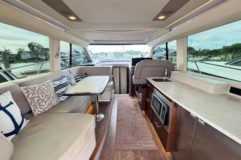 Blue Skies Yacht Photos Pics Luxurious interior of 2017 Regal 42 Fly yacht with seating, table, and kitchenette.