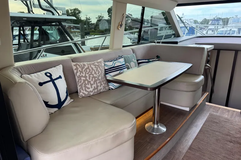 Blue Skies Yacht Photos Pics Luxurious interior of 2017 Regal 42 Fly yacht with cozy seating and nautical-themed pillows.