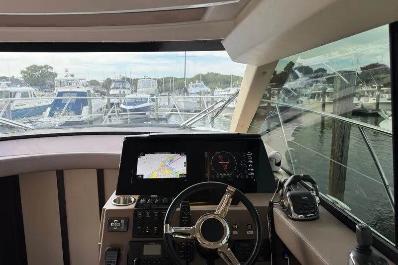Blue Skies Yacht Photos Pics Cockpit view of 2017 Regal 42 Fly yacht with navigation screens and marina backdrop.