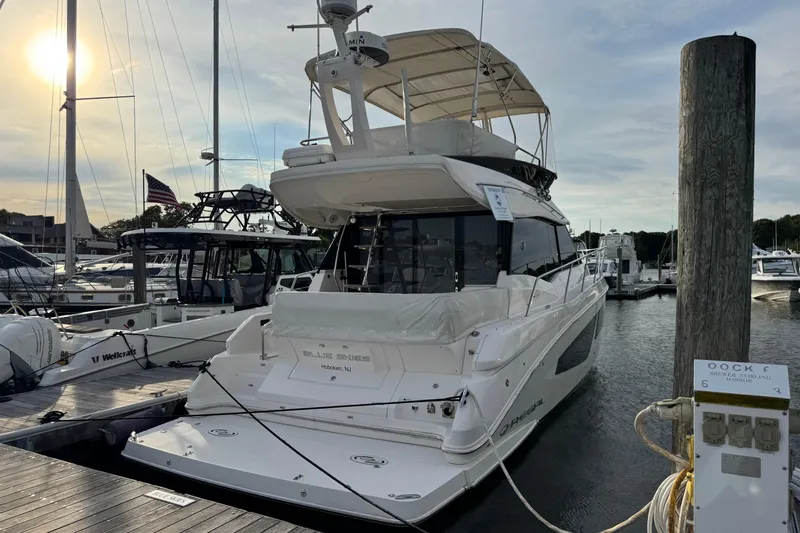 Blue Skies Yacht Photos Pics 2017 Regal 42 Fly yacht docked at marina, sun setting in background.