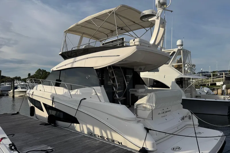 Blue Skies Yacht Photos Pics 2017 Regal 42 Fly yacht docked at marina, showcasing sleek design and spacious flybridge.
