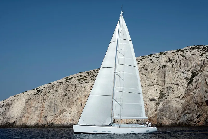 Polytropon II Yacht Photos Pics Swan 82 sailboat from 2008 by Nautor Swan, sailing near rocky coastline.