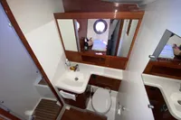 Bathroom interior of 2011 Beneteau Swift Trawler 52 with sink, toilet, and mirror.