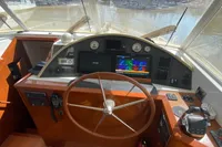 Helm of 2011 Beneteau Swift Trawler 52 with navigation equipment and wooden steering wheel.