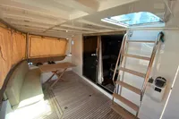 2011 Beneteau Swift Trawler 52 interior with seating, table, and wooden flooring.