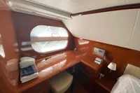 Luxurious cabin interior of 2011 Beneteau Swift Trawler 52 with wooden finish and porthole.