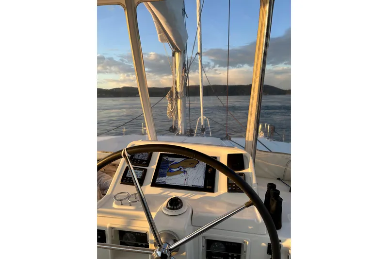 "lagu" Yacht Photos Pics Helm view of 2011 Lagoon 450 catamaran with navigation equipment, sailing at sunset.