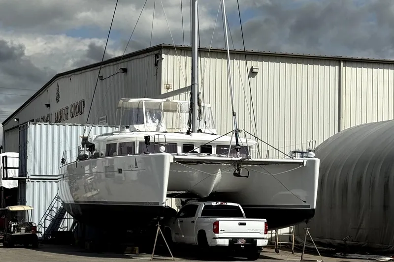 "lagu" Yacht Photos Pics 2011 Lagoon 450 catamaran in shipyard, parked above white truck, overcast sky.